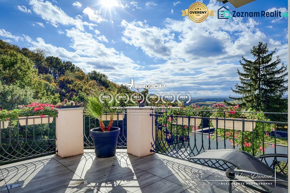 7-izbový rodinný dom s úžasným výhľadom v prestížnej lokalite Devín - Balkón rodinného domu v Bratislave - Devíne s výhľadom na les a kvetinová výzdoba.