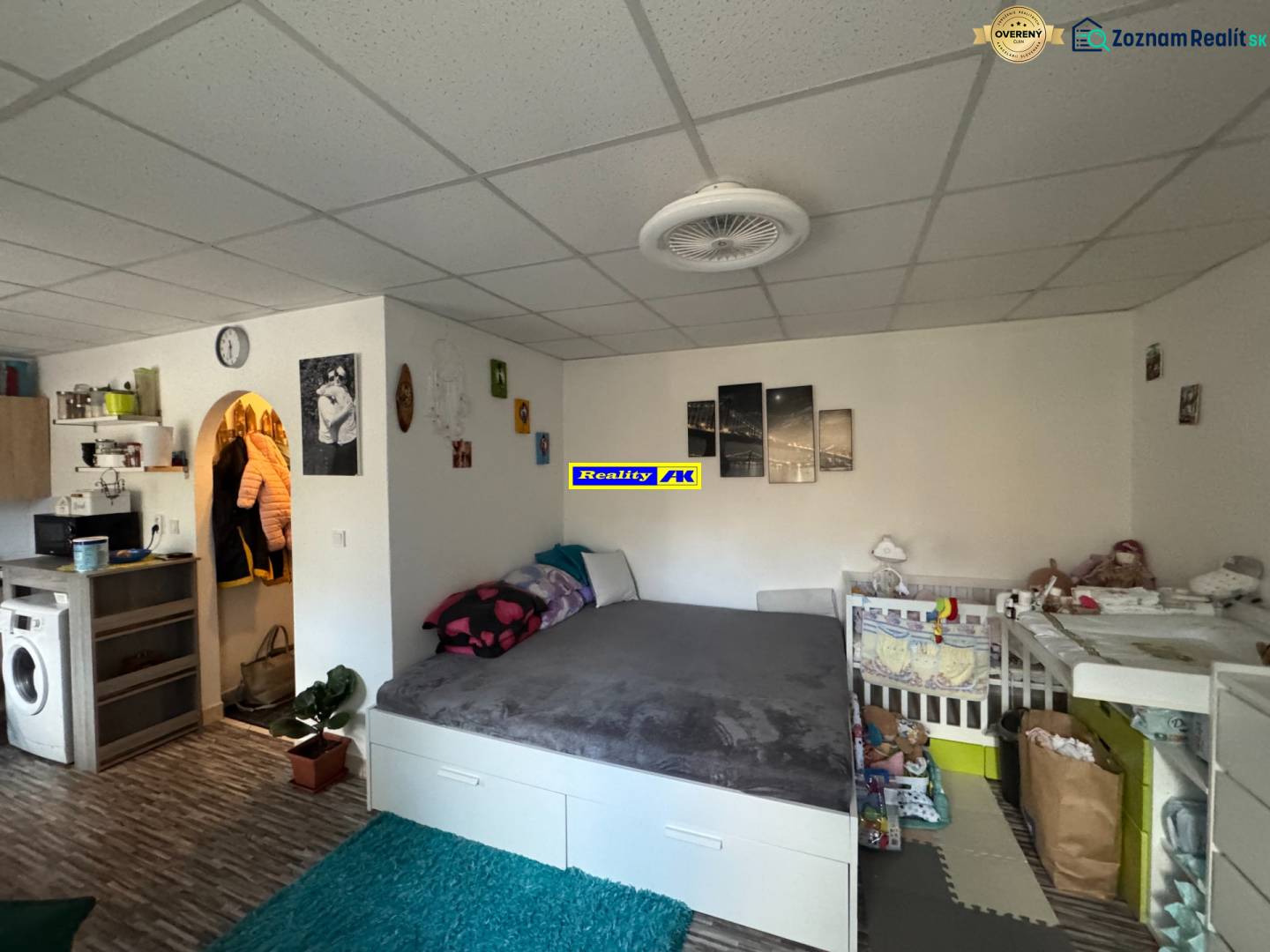REZERVOVANÉ jednoizbový zrekonštruovaný byt v širšom centre mesta - Izba v 1-izbovom byte s posteľou a detskou postieľkou, podlaha s dreveným dekorom.