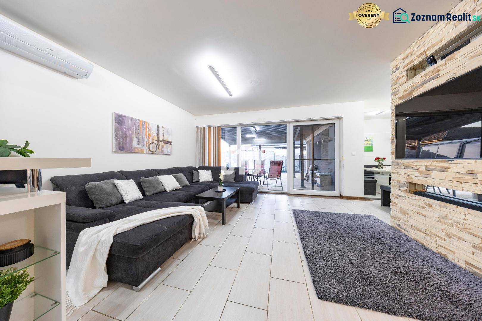 Tri Vody - 4-izbový rodinný dom s bazénom | Most pri Bratislave – Baza - Obývacia izba rodinného domu s pohovkou, krbom a posuvnými dverami na terasu.