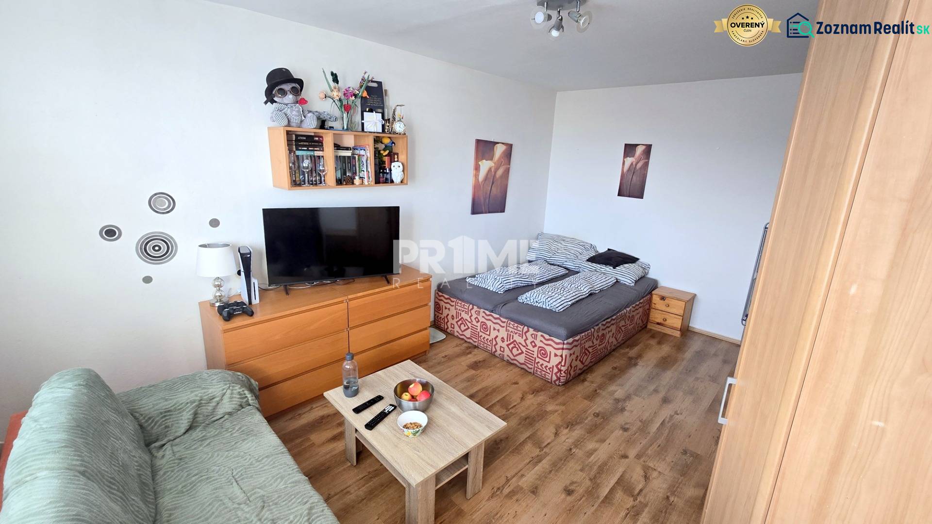 Príjemný 1i byt, zariadený, pivnica, Drobného ul., Dúbravka - Obývacia izba v 1-izbovom byte s pohovkou, posteľou a podlahou s dreveným dekorom.