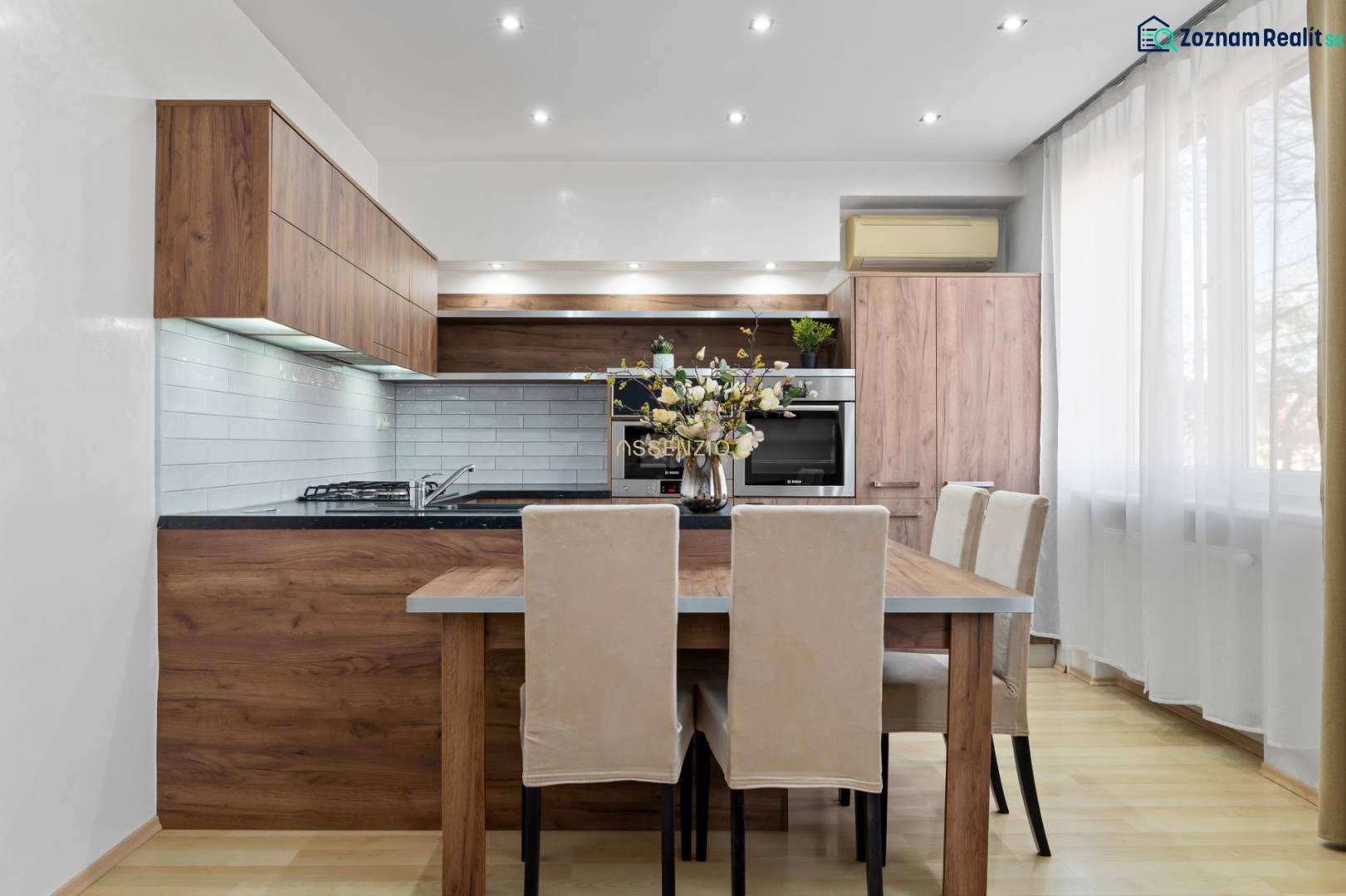 PREDAJ-2 IZBOVÝ BYT-KOMPLETNÁ REKONŠTRUKCIA - RUŽINOV - Kuchyňa v 2-izbovom byte s dreveným dekorom a svetlým nábytkom.