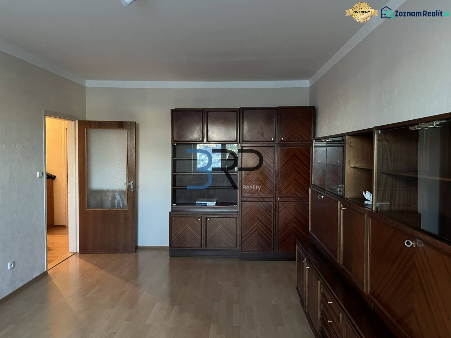 REZERVOVANÝ! Na predaj 2izbový byt v meste Senica - Obývacia izba v 2-izbovom byte s veľkou drevenou obývačkovou súpravou a podlahou s dreveným dekorom.