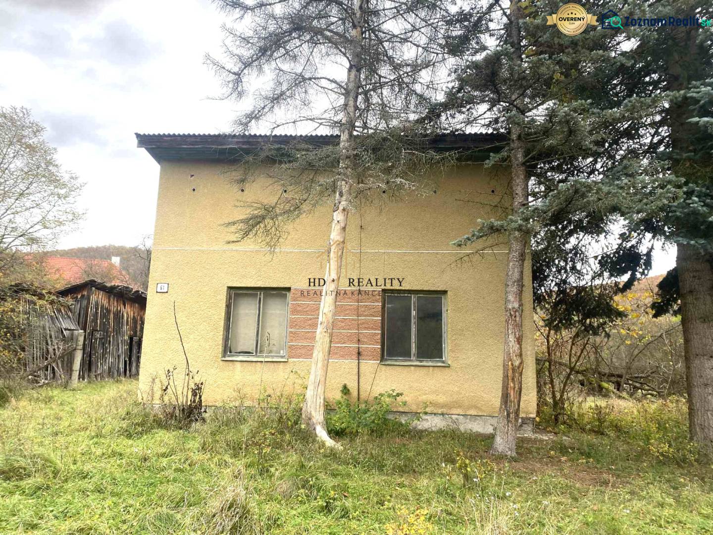 HD reality ponúka, predaj, rodinný dom Rykynčice  - Rodinný dom v Rykynčiciach, obklopený stromami so svahovým pozemkom a drevenou prístavbou.