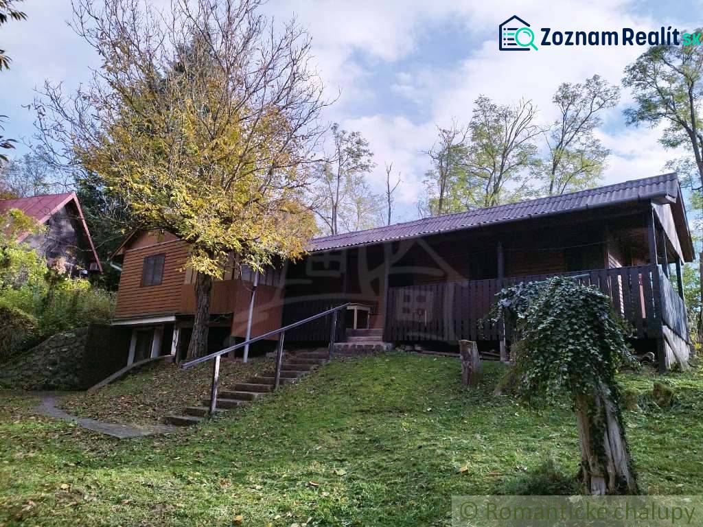 Chata nad kúpeľmi Dudince s vlastným pozemkom - Chata v Dudinciach obklopená prírodou s terasou a stromami na dvore.