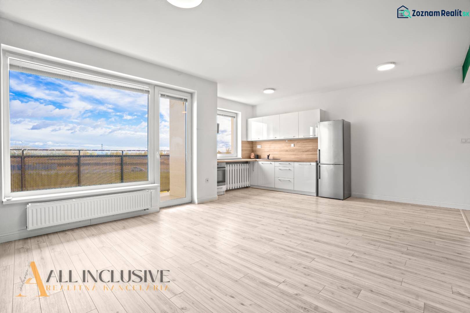 NA PRENÁJOM 2x 2-IZBOVÉ BYTY S TERASOU,DUNAJSKÁ STREDA - Svetlý interiér 2-izbového bytu s kuchyňou, presklenou stenou a podlahou s dreveným dekorom.