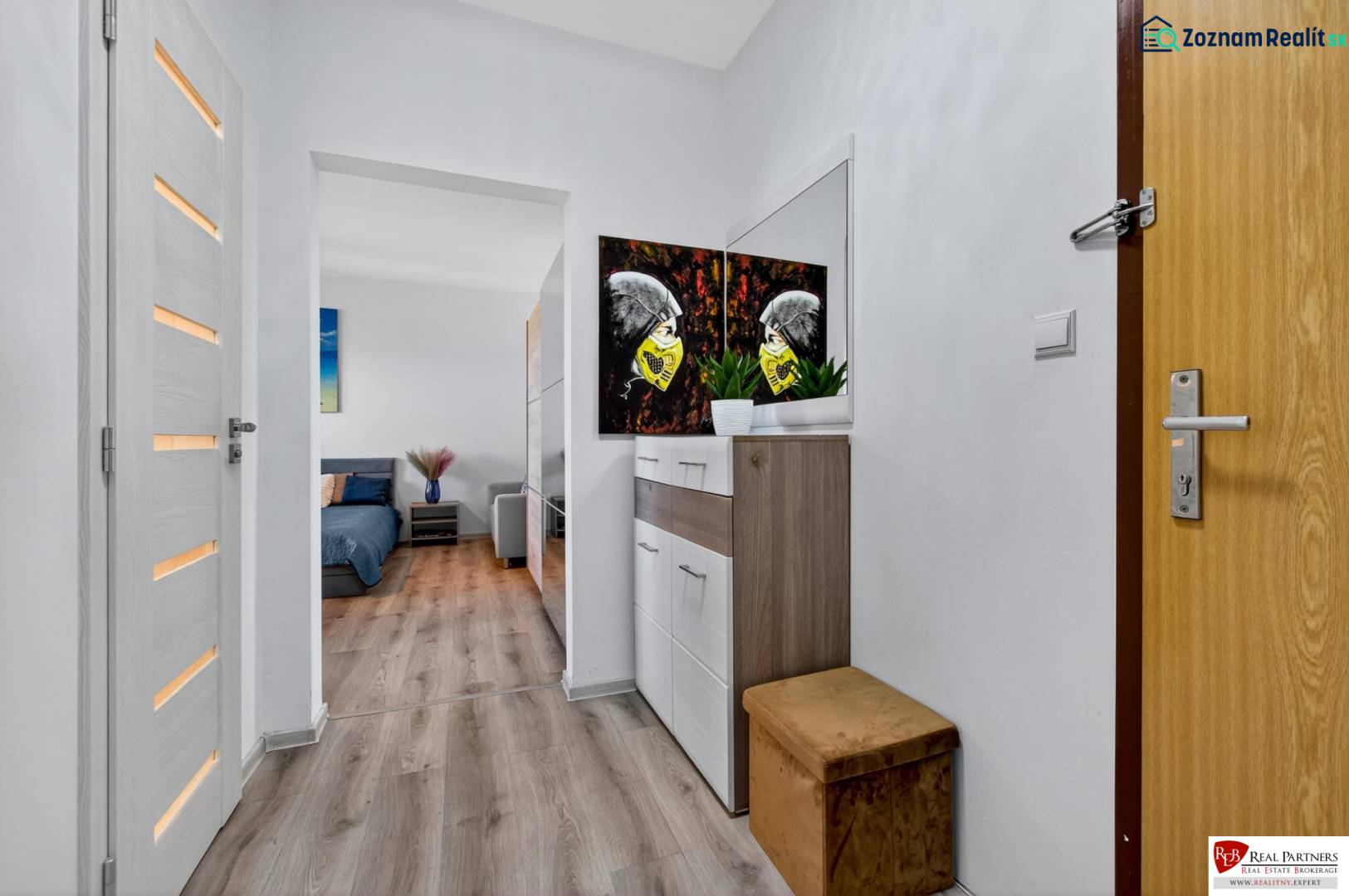 REZERVOVANÉ Predaj moderný 1-izbový byt, 45,24m2, Bratislava IV - Chodba v 1-izbovom byte s podlahou s dreveným dekorom a dekoráciou na stene.