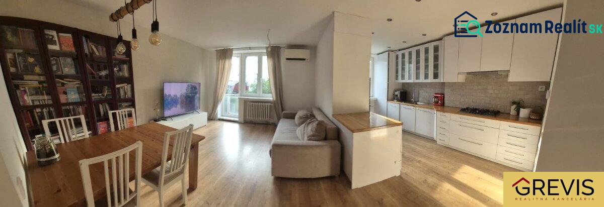 Elegantný 3 izbový byt (78 m²) s 2 balkónmi po kompletnej rekonštrukci - Priestranná kuchyňa s obývačkou v 3-izbovom byte. Podlaha s dreveným dekorom, svetlý nábytok.