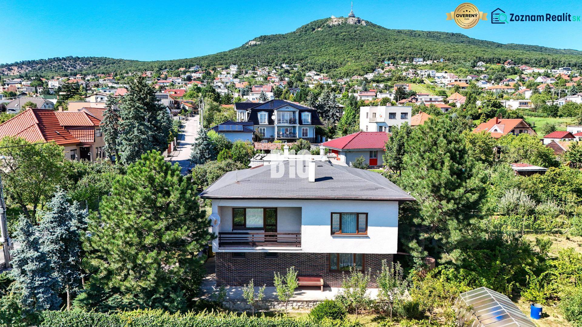 Rodinný dom s nádherným 8 árovým pozemkom na Kamennej ulici - Rodinný dom na Kamennej ulici v Nitre obklopený zeleňou a ďalšími domami.