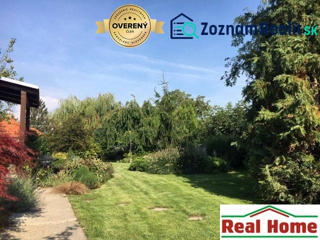 Dom s garážou na peknom rovinatom pozemku so šírkou 24m. - Záhrada pri rodinnom dome v Čiernej Vode s bohatou výsadbou a udržiavaným trávnikom.