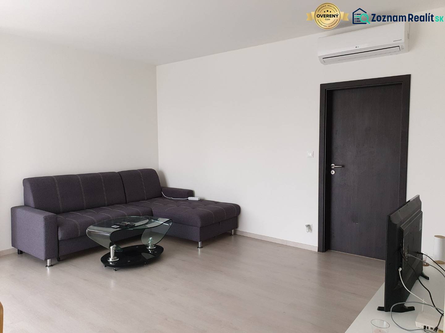 PRENÁJOM - Byt s krásnym výhľadom - Nitra, Dolnohorská - Obývacia izba v 2-izbovom byte so sivou sedačkou a podlahou s dreveným dekorom.