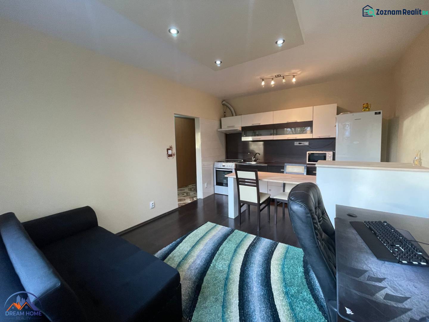 MH279-Na predaj 1 izbový byt v oblúbenej lokalite Komárna! - Interiér 1-izbového bytu s kuchynským kútom a podlahou s dreveným dekorom.