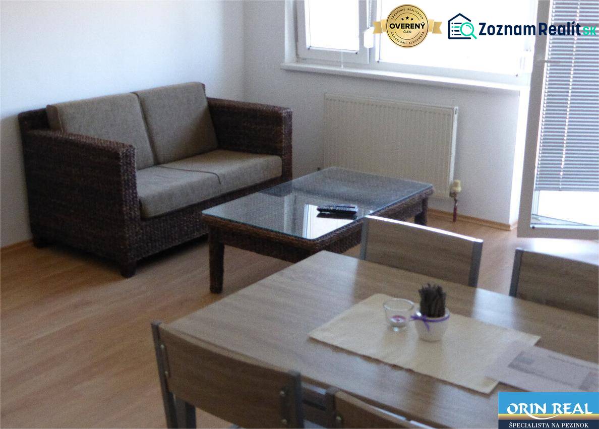 Na predaj 2 izbový byt s parkovacím státím Zemplínska ul. - Obývačka s prútenou sedačkou, sklom na stole a podlahou s dreveným dekorom.