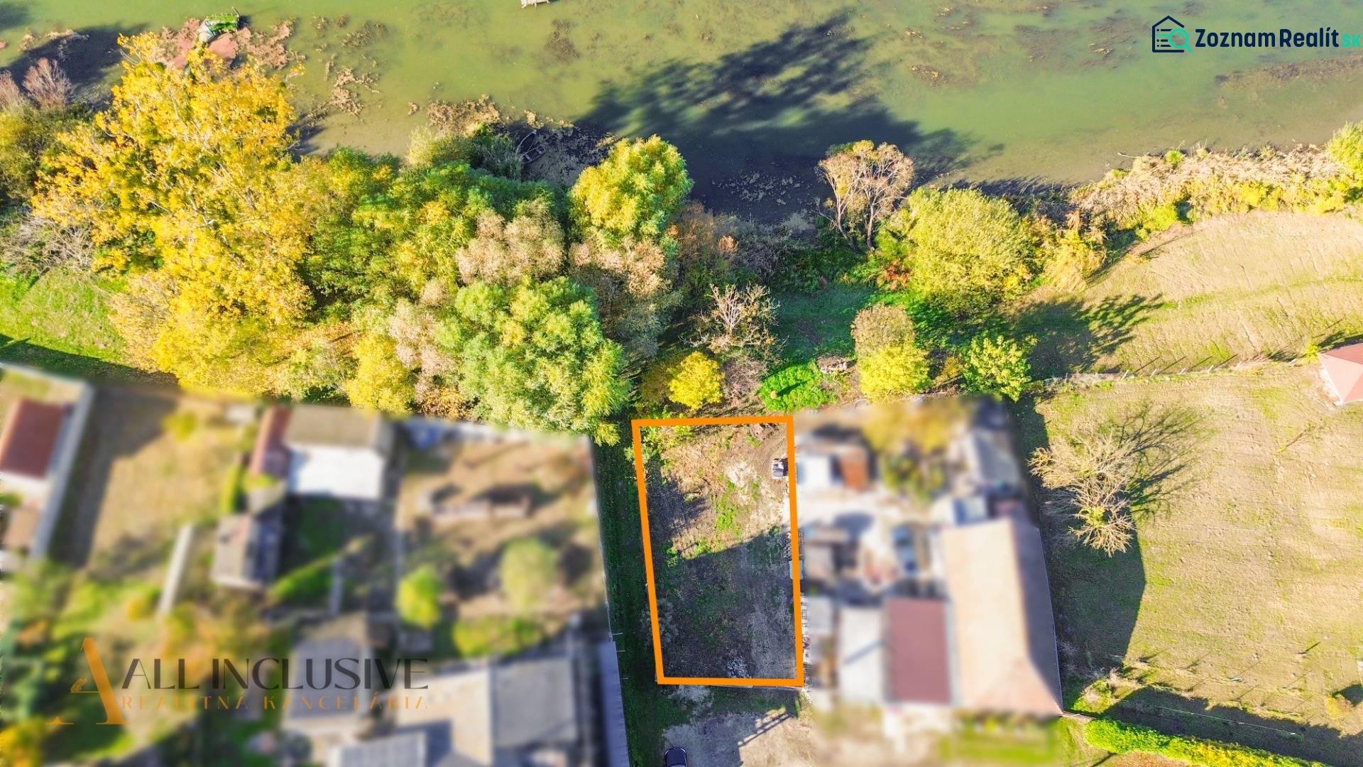 NA PREDAJ STAVEBNÝ POZEMOK, JAHODNÁ - Letecký pohľad na pozemok v Jahodnej určený na bývanie, obklopený zeleňou blízko vody.