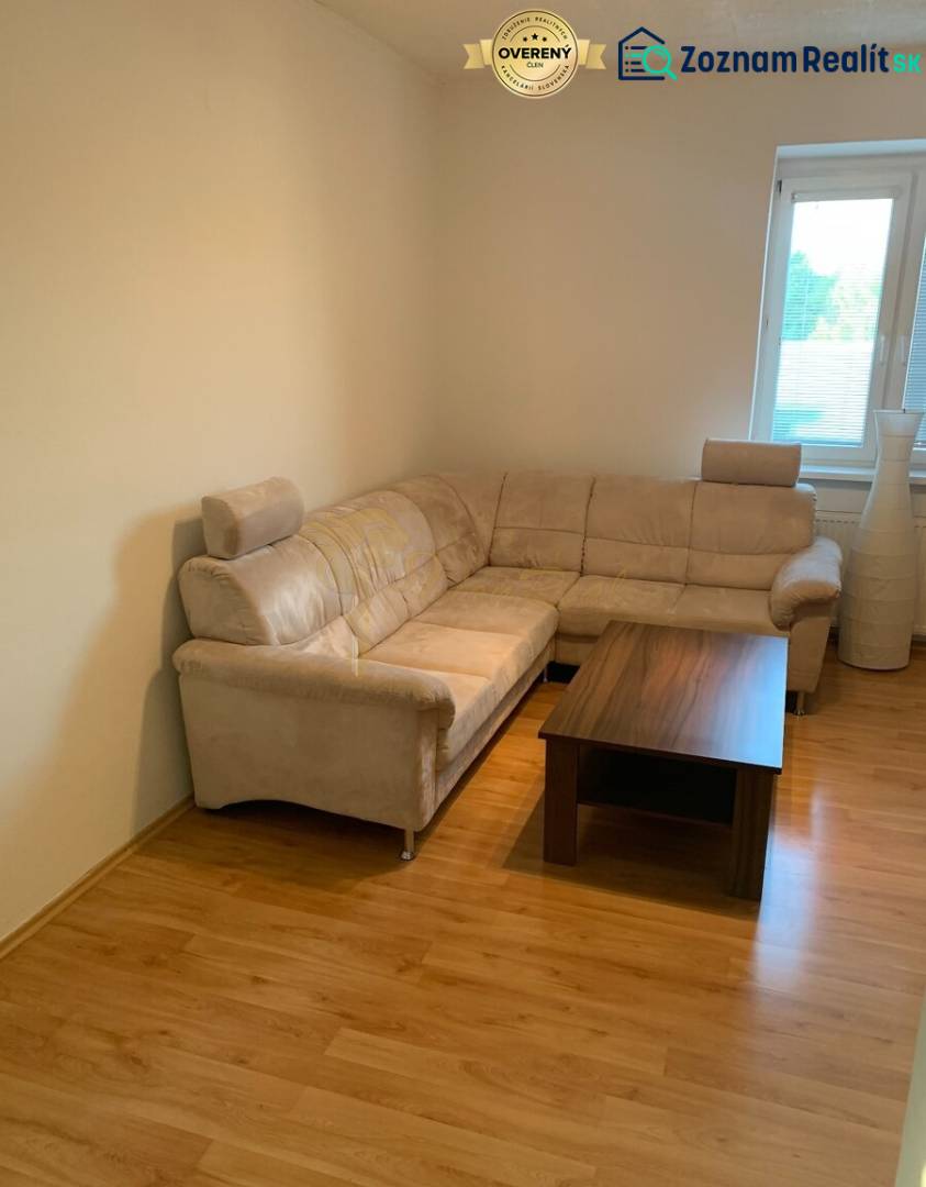 2-izb. byt, Tylova ul., Nové Mesto, tehlový dom - Obývacia izba s pohodlnou sedačkou a stolíkom na podlahe s dreveným dekorom.