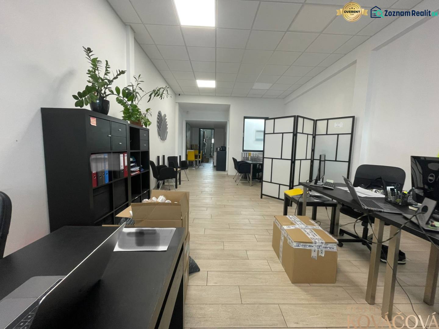 Na prenájom komerčné priestory v priemyselnej zóne v Trenčíne - Obchodné priestory s poličkou, stolmi, kreslami a podlahou s dreveným dekorom.