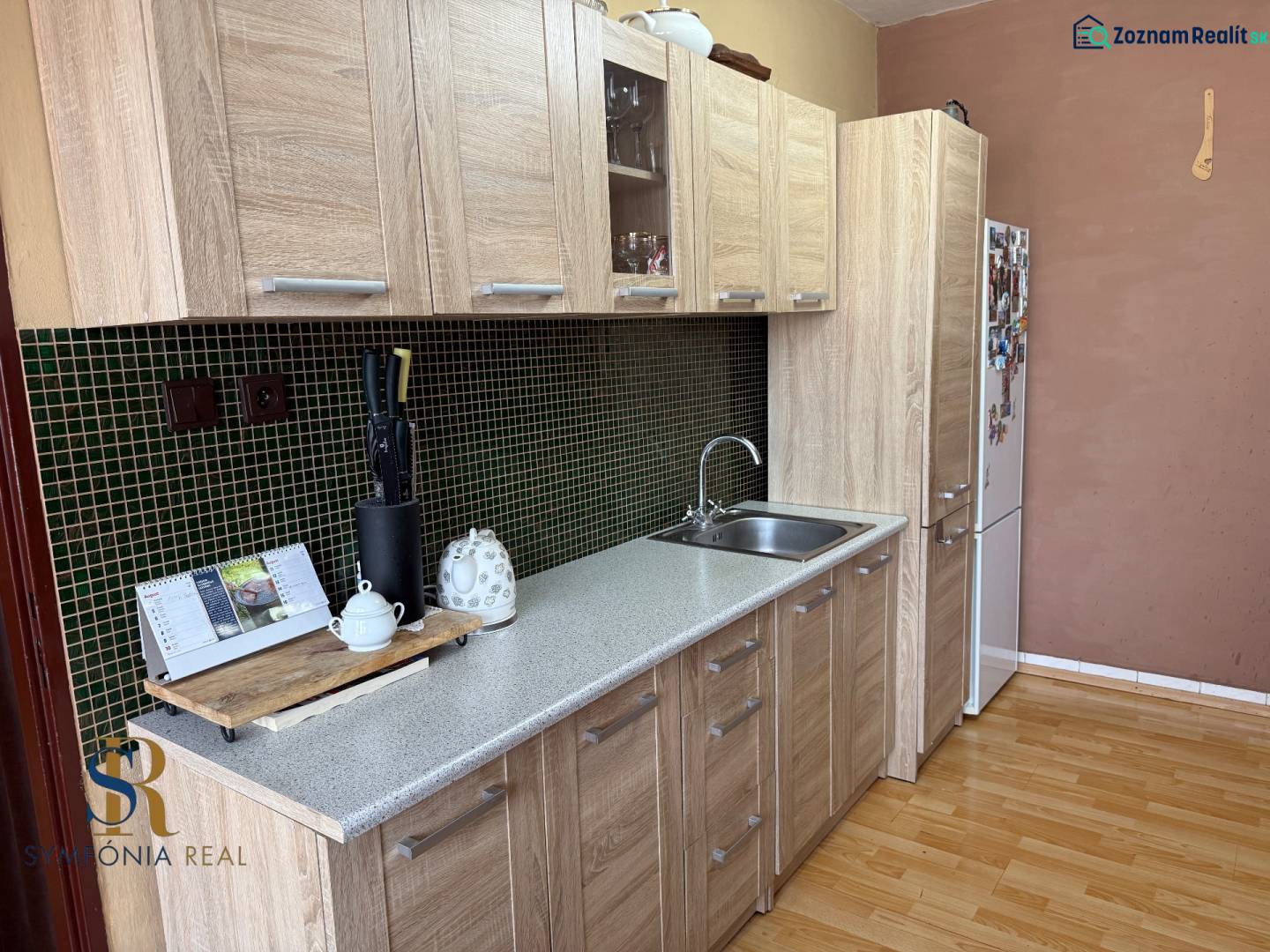5-izbový rodinný dom v Borskom Mikuláši - bez rezervačej zálohy - Kuchyňa v rodinnom dome s podlahou s dreveným dekorom a svetlým nábytkom.