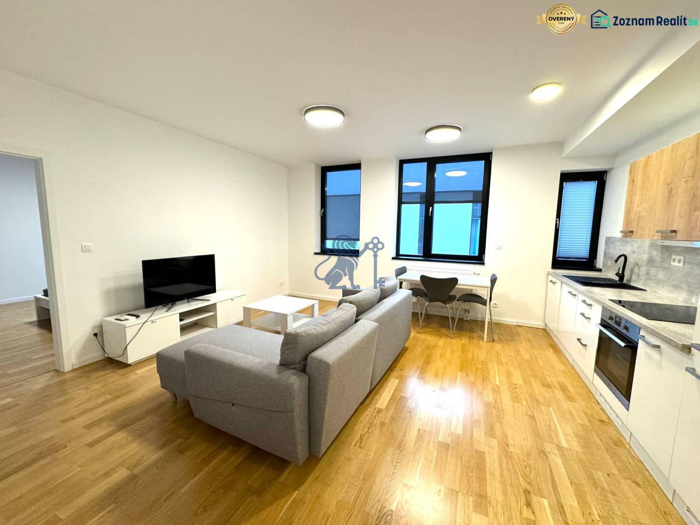 Budova s 8 apartmánmi alebo medicínske centrum, 9 park. miest- Koliba - Obývačka s kuchyňou, pohovkou a televíziou, ulica Na varte. Obchodné priestory v okolí.