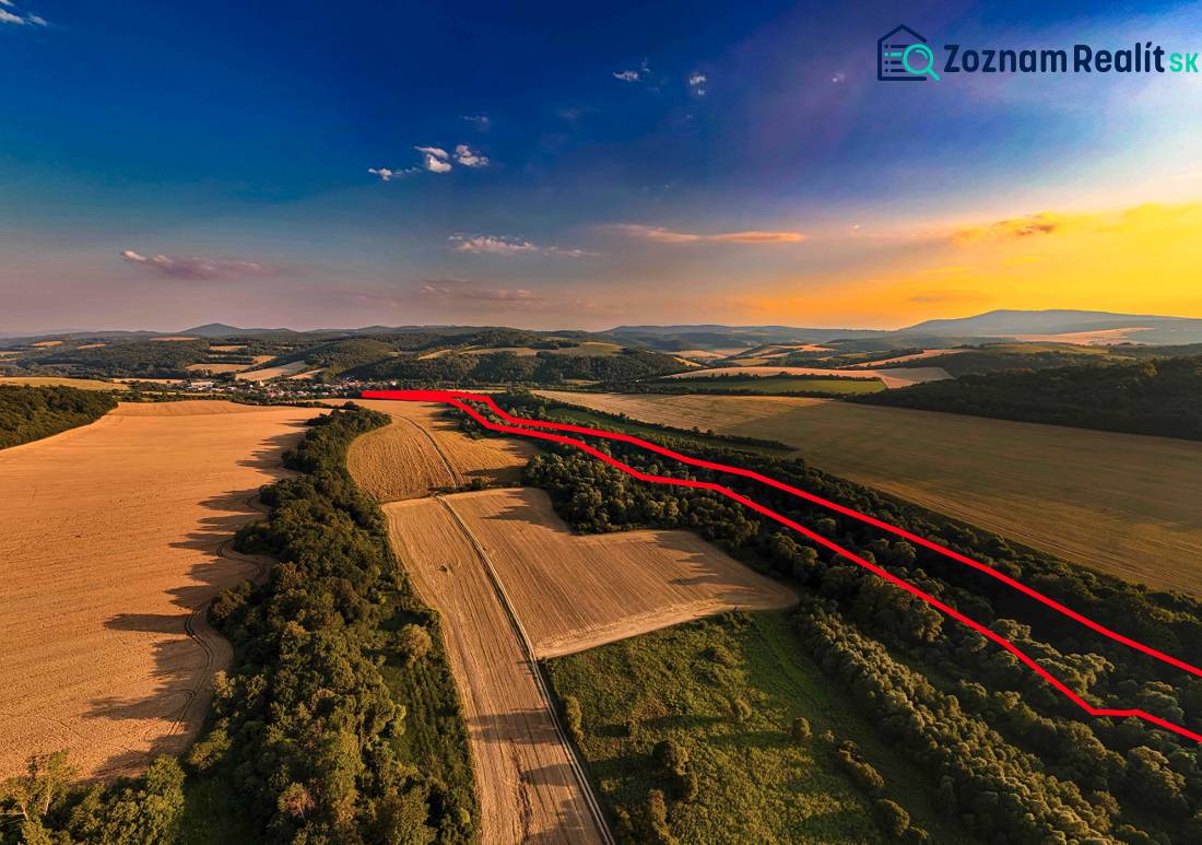 Rokycany – 38.000 m2 LESNÝ POZEMOK v podiele 1/1 - Poľnohospodárske a lesné pozemky v Rokycanoch pri západe slnka, s viditeľnou červenou čiarou.