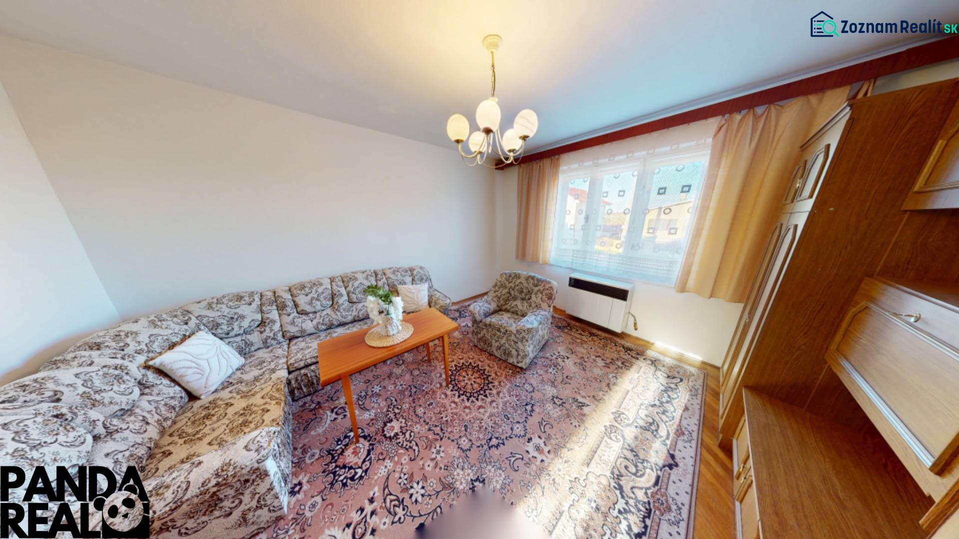 Rodinný dom v obci Bojná - Obývacia izba v Rodinnom dome s pohovkou, kobercom a drevenými skriňami.