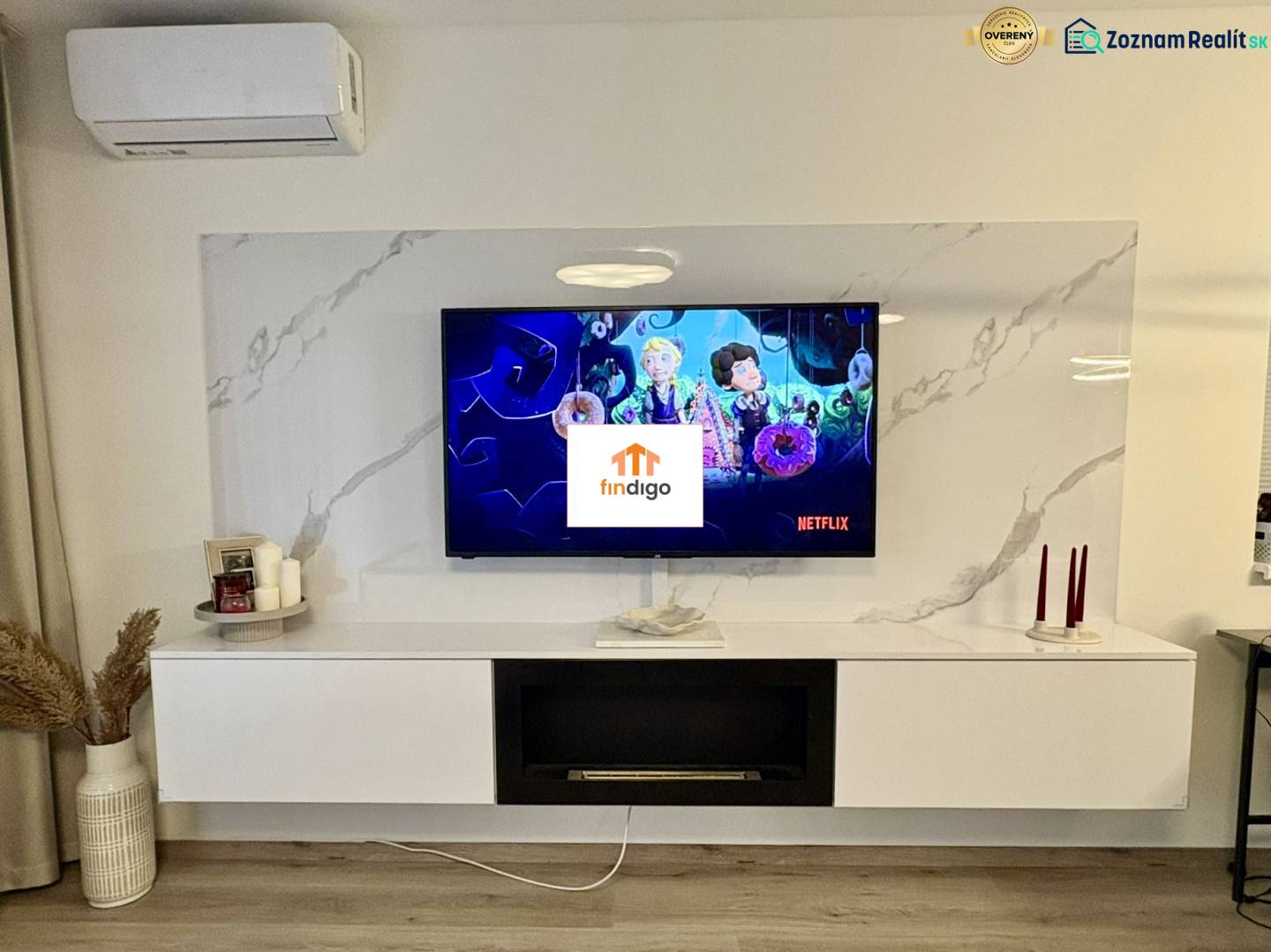 PRENÁJOM - 3-izbový veľkometrážny byt v RED OAK, Lužianky -REZERVOVANÉ - Obývacia izba v 3-izbovom byte s televízorom, policami a podlahou s dreveným dekorom.