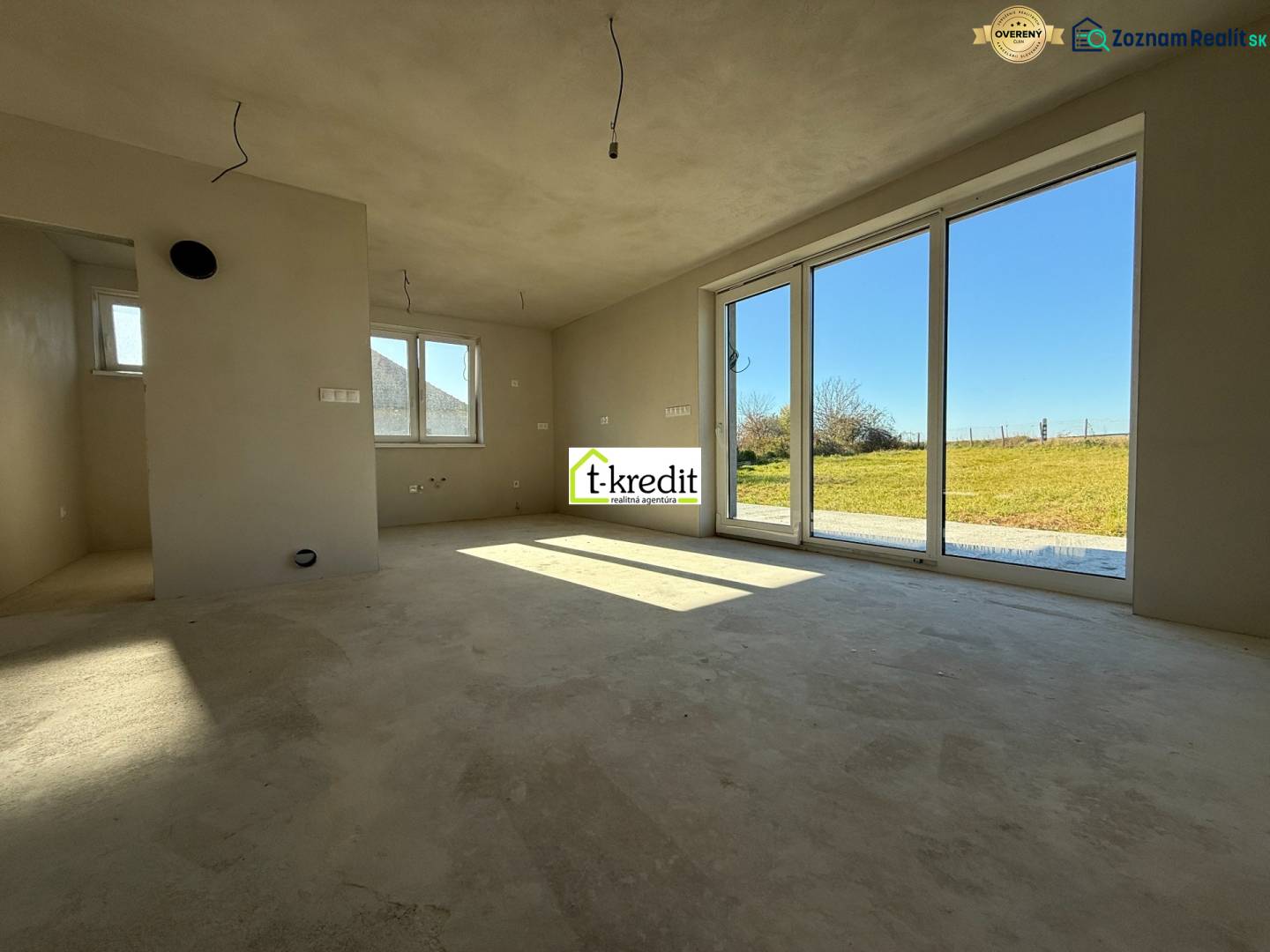 PREDAJ - NOVOSTAVBA - TESÁRSKE MLYŇANY - Priestranný interiér rodinného domu s veľkými oknami a výhľadom na záhradu.