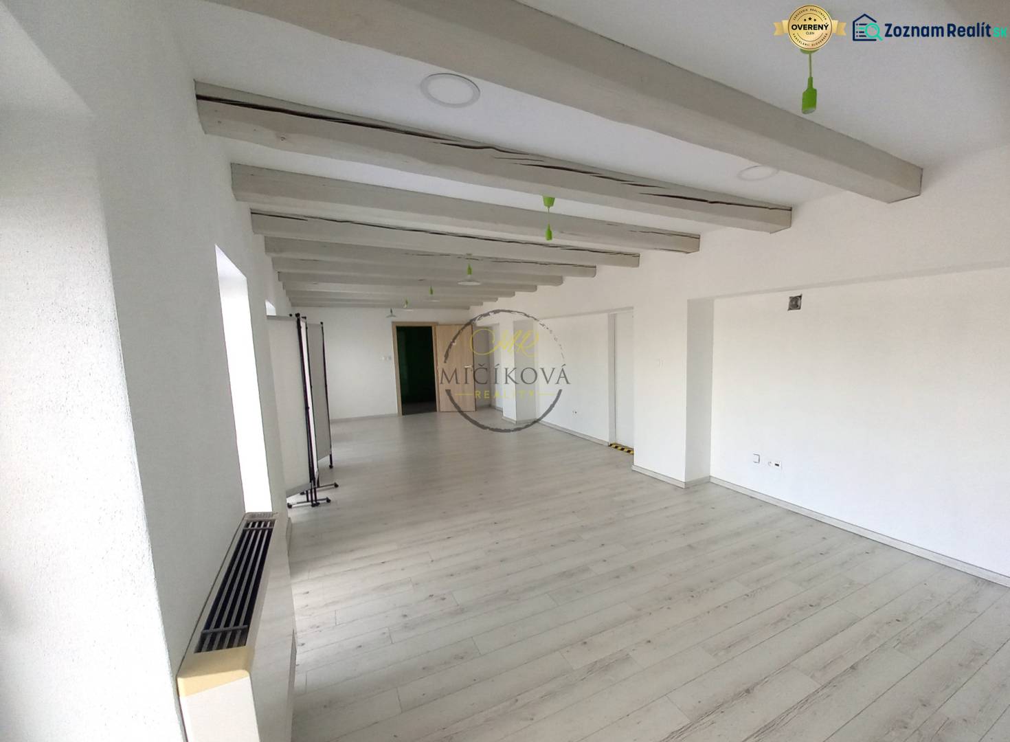 Prenajmeme kancelársky priestor, 40 m2, Levická ul., Vráble - Prázdna kancelária s bielymi stenami a podlahou s dreveným dekorom.