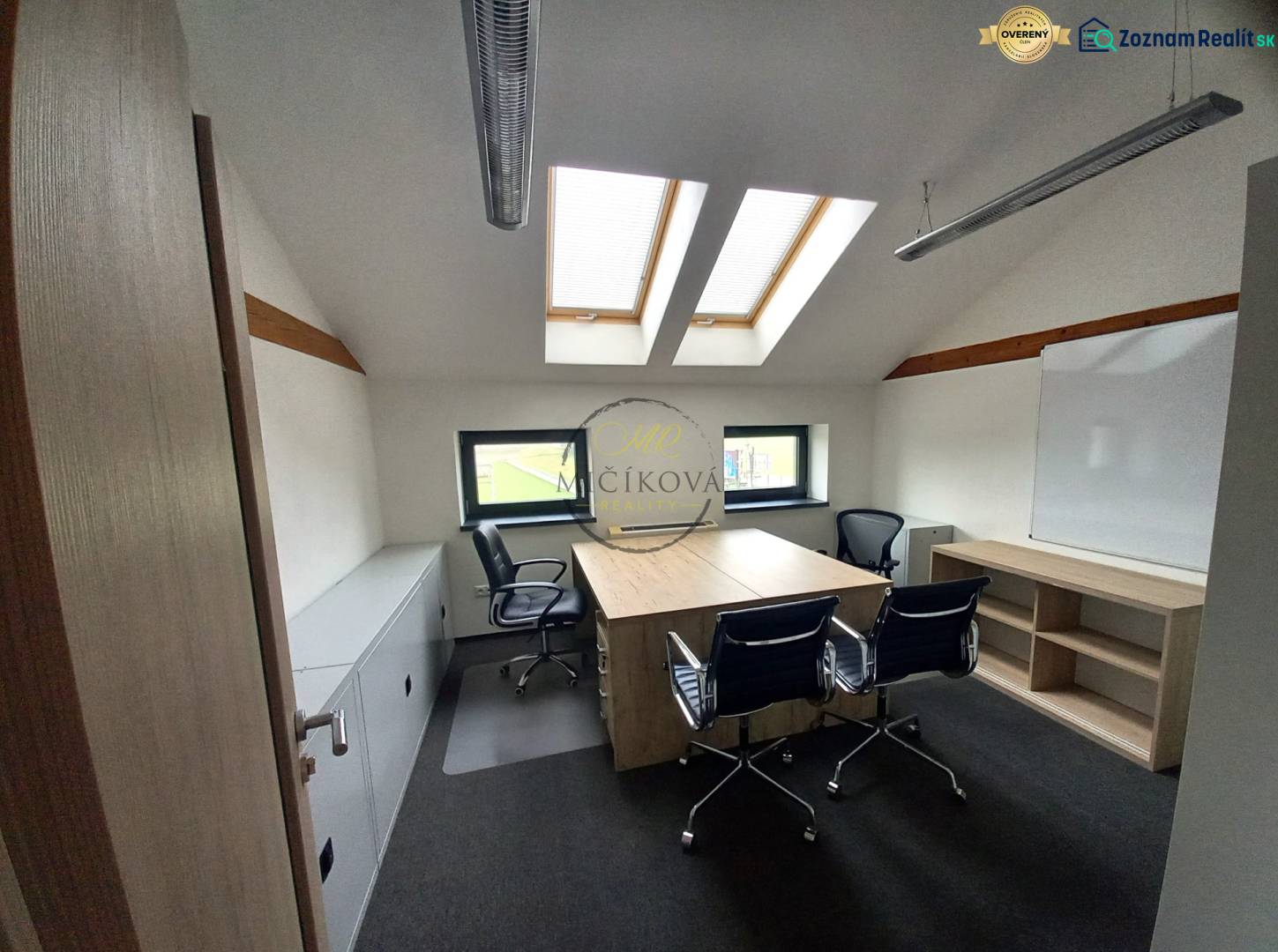 Ponúkame na prenájom kanceláriu, 15,54 m2, Levická ul., Vráble - Kancelária s podlahou s dreveným dekorom, strešnými oknami a stolmi so stoličkami.