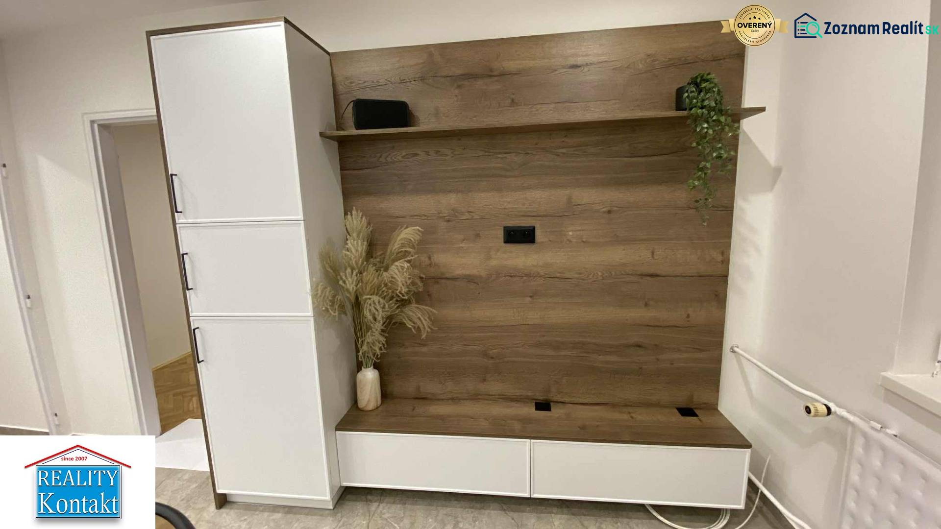 Na prenájom 1-izbový byt - Nové Zámky - V 1-izbovom byte je šatníková stena s dreveným dekorom a kvetmi vo váze.