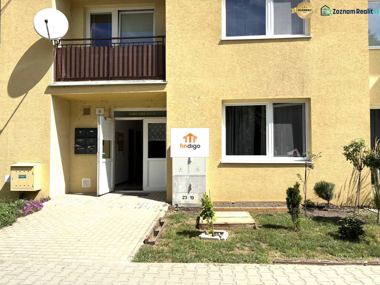 PREDAJ-  2 izbový byt neďaleko Nitry v obci Jarok - Vstup do budovy s 2-izbovým bytom v Jarku, so satelitnou anténou na balkóne.