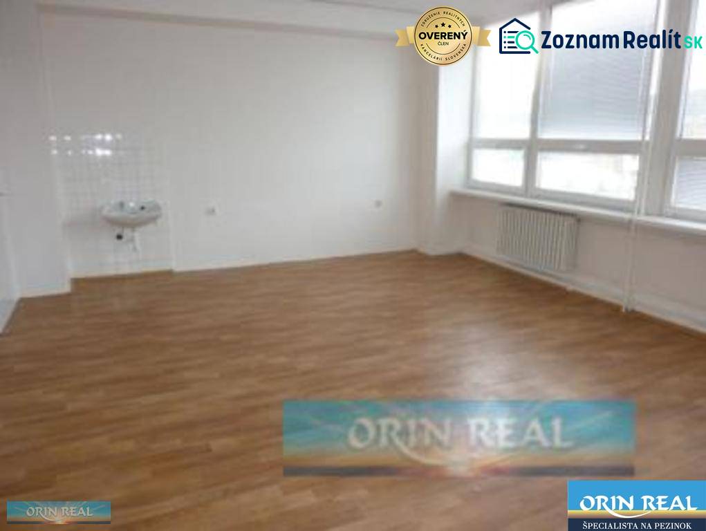 PRENÁJOM KANCELÁRSKÝCH PRIESTOROV NA RAČIANSKEJ ULICI - Prázdna miestnosť s umývadlom, drevená podlaha, veľké okná na ulici Račianska.