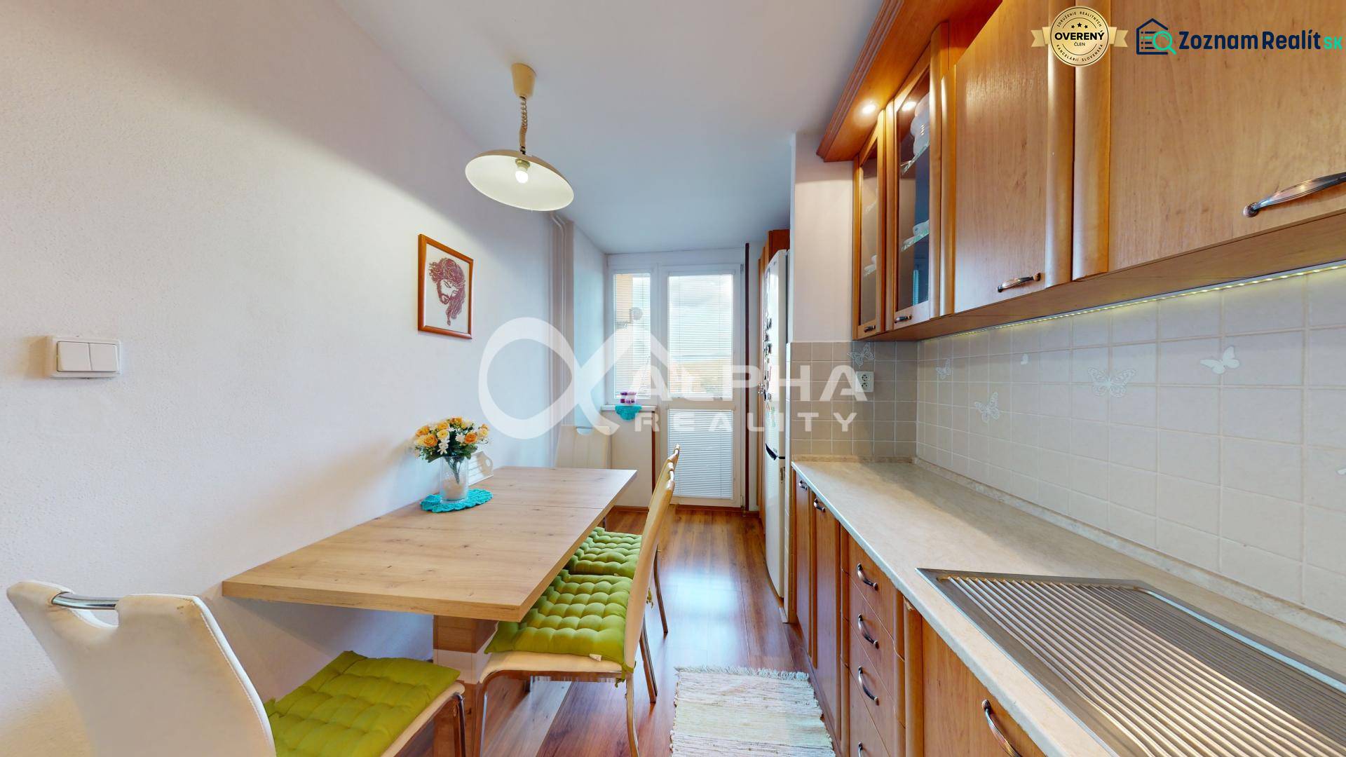 EXKLUZÍVNE 3i byt s loggiou, Spišské Podhradie - Kuchyňa so stolom a stoličkami, drevené skrinky, podlaha s dreveným dekorom.