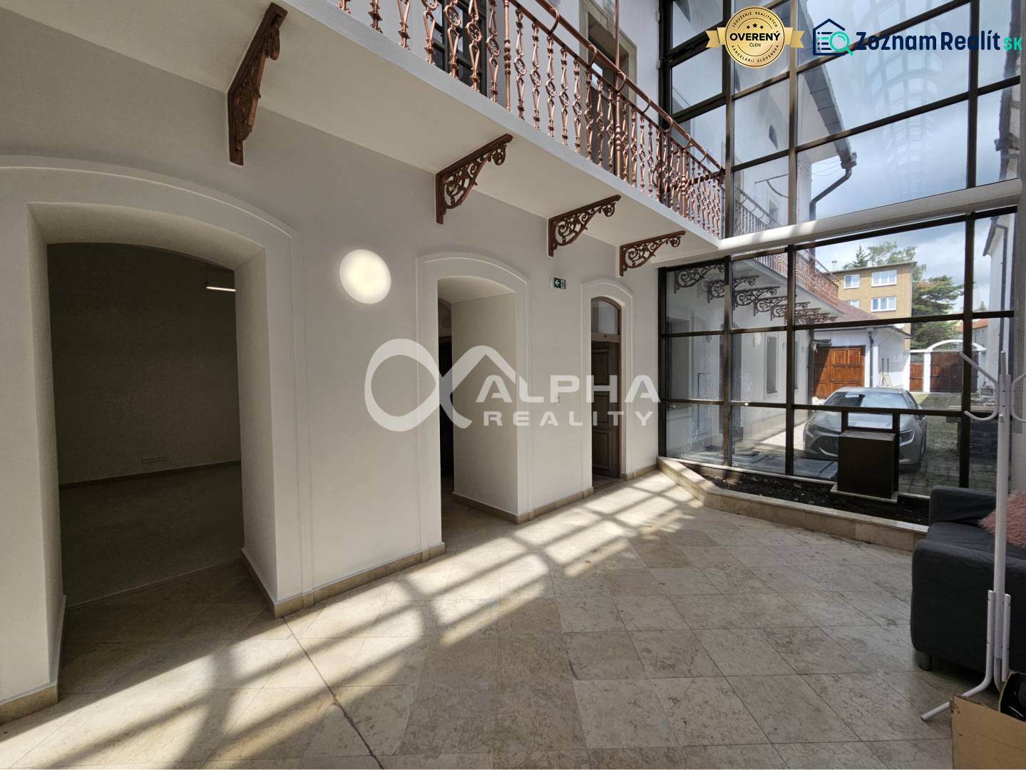 Prenájom obchodných priestorov, 268m2, Letná ulica, Spišská Nová Ves - Interiér obchodných priestorov s kamennou podlahou a presklenou stenou; svetlé miestnosti.