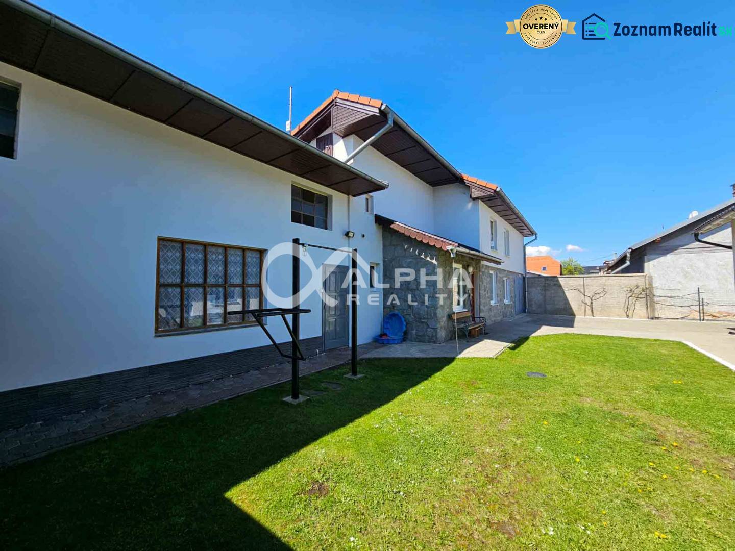 EXKLUZÍVNE Rodinný dom, širšie centrum, Spišská Nová Ves - Rodinný dom v Spišskej Novej Vsi s trávnatým dvorom a kamennými prvkami na fasáde.
