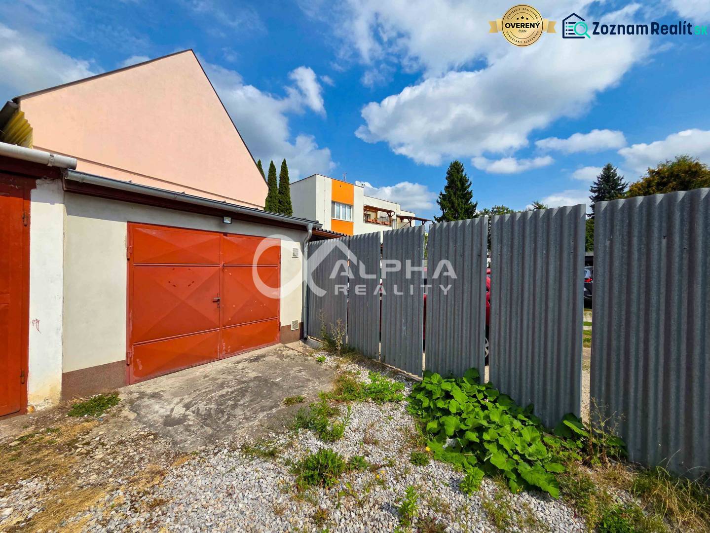 Prenájom garáž, centrum, Spišská Nová Ves - Garáže v Spišskej Novej Vsi s plechovým plotom, obložené červenými dverami.