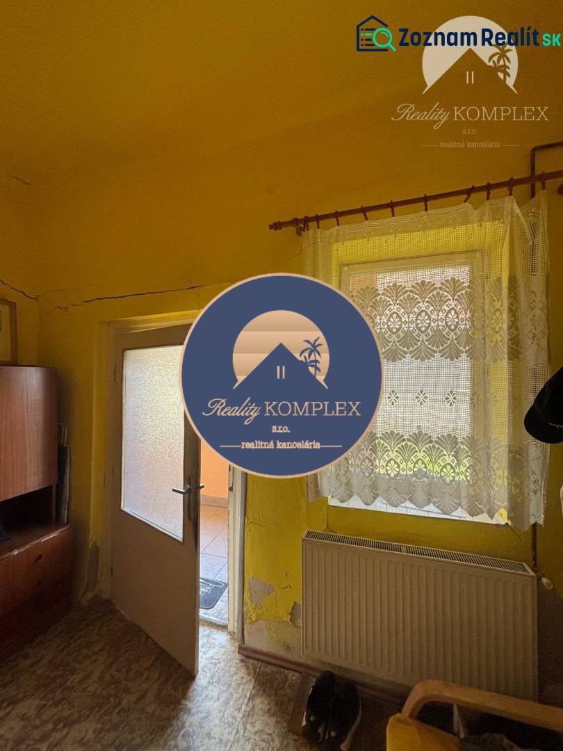 Reality KOMPLEX Vám ponúka EXKLUZÍVNE na predaj rodinný dom, ktorý sa  - Predsieň v rodinnom dome, s podlahou s dreveným dekorom a žltými stenami.