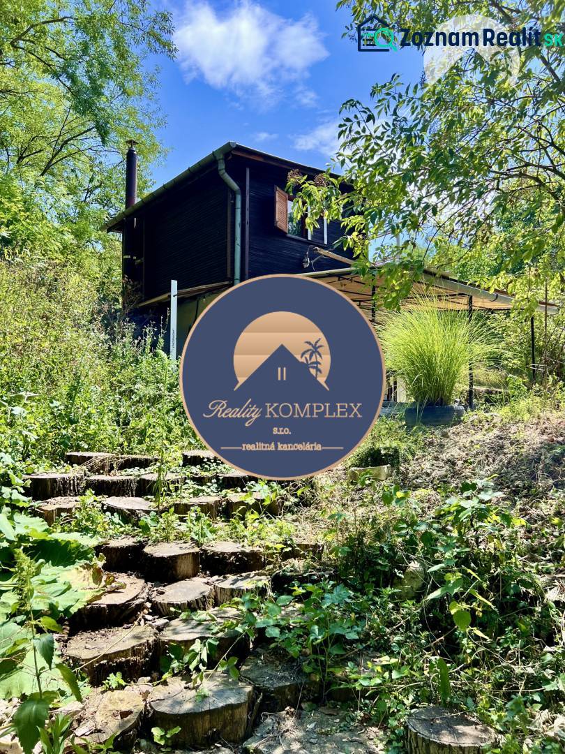 Ponúka na PREDAJ viničný domček s priestranným  - Chata v Kameníne so schodmi z dreva, obklopená zeleňou a stromami.