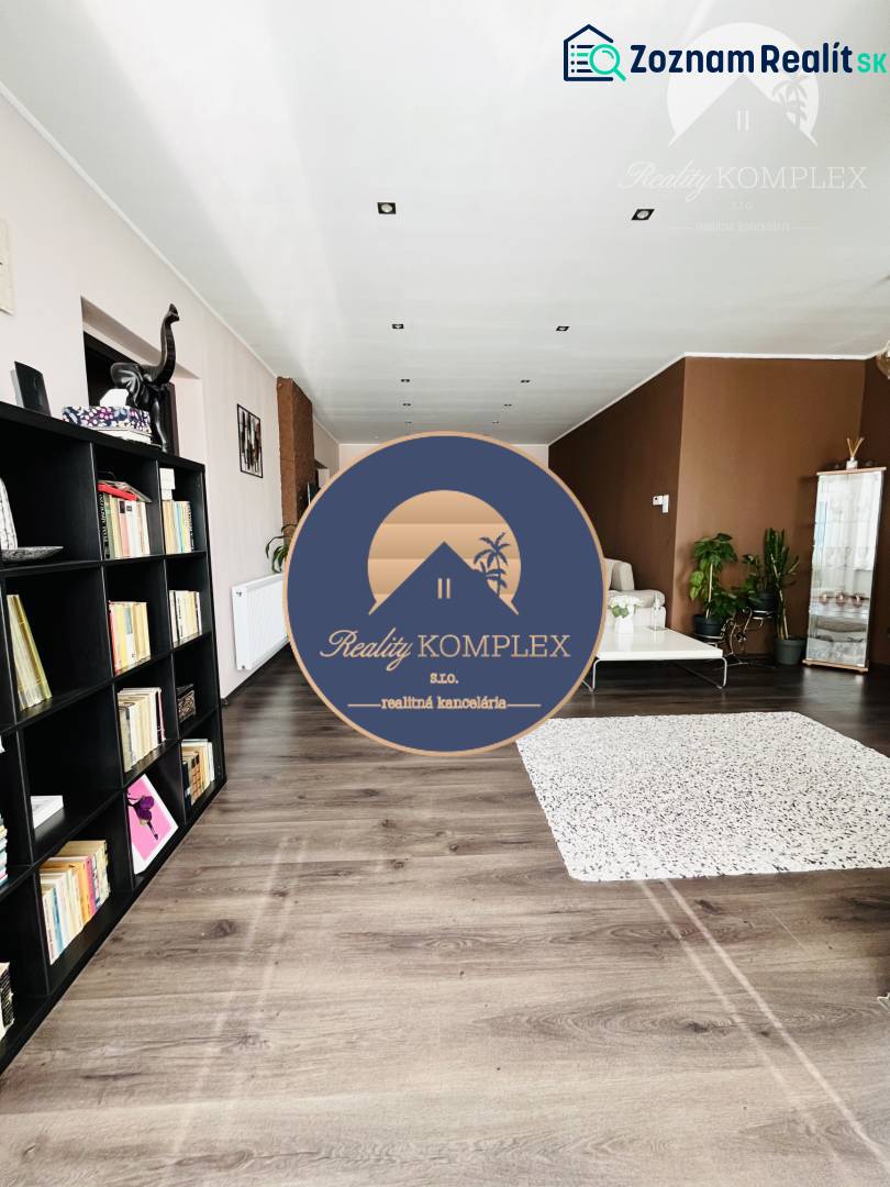Vám ponuka na predaj útulný 3-izbový rodinný d - Obývacia izba v rodinnom dome s policami a podlahou s dreveným dekorom.