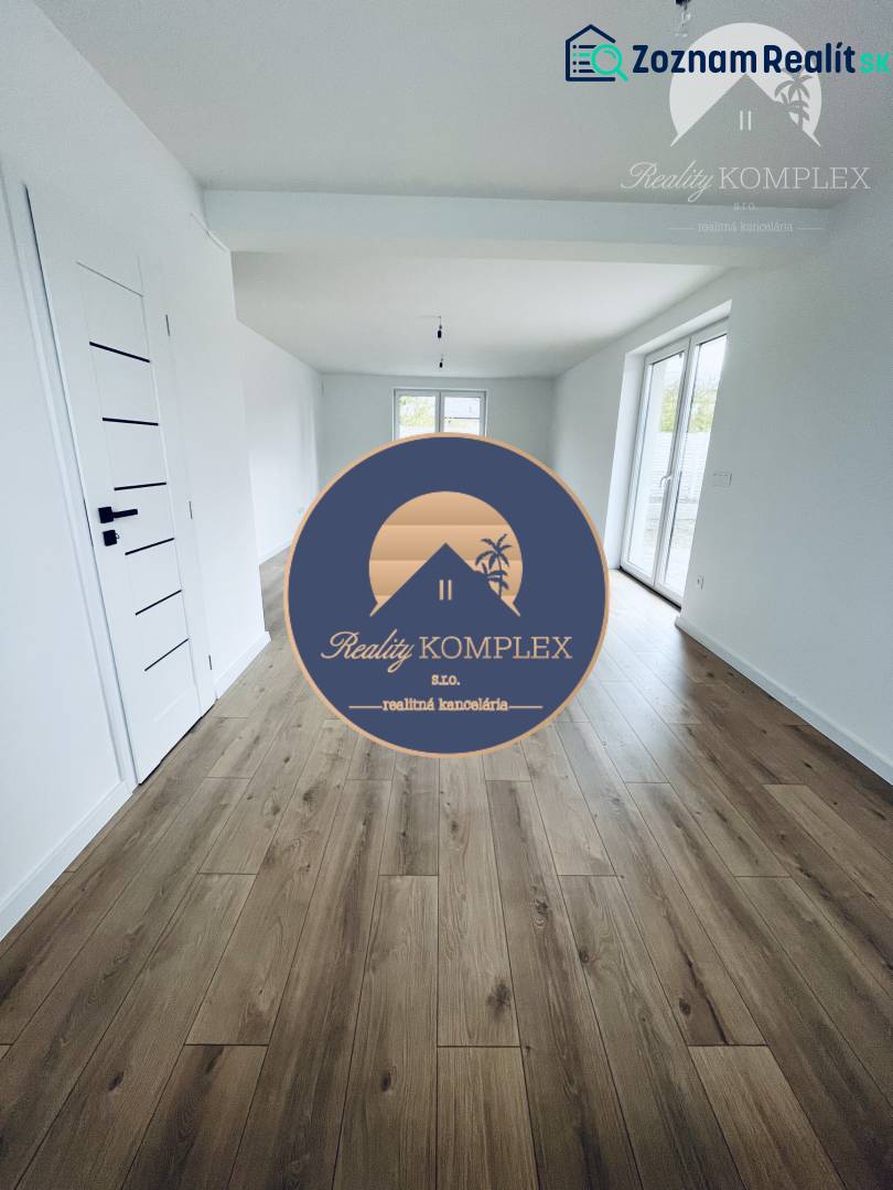 Vám ponúka na predaj moderný 4-izbový bungalov - Interiér rodinného domu s bielymi stenami a podlahou s dreveným dekorom.