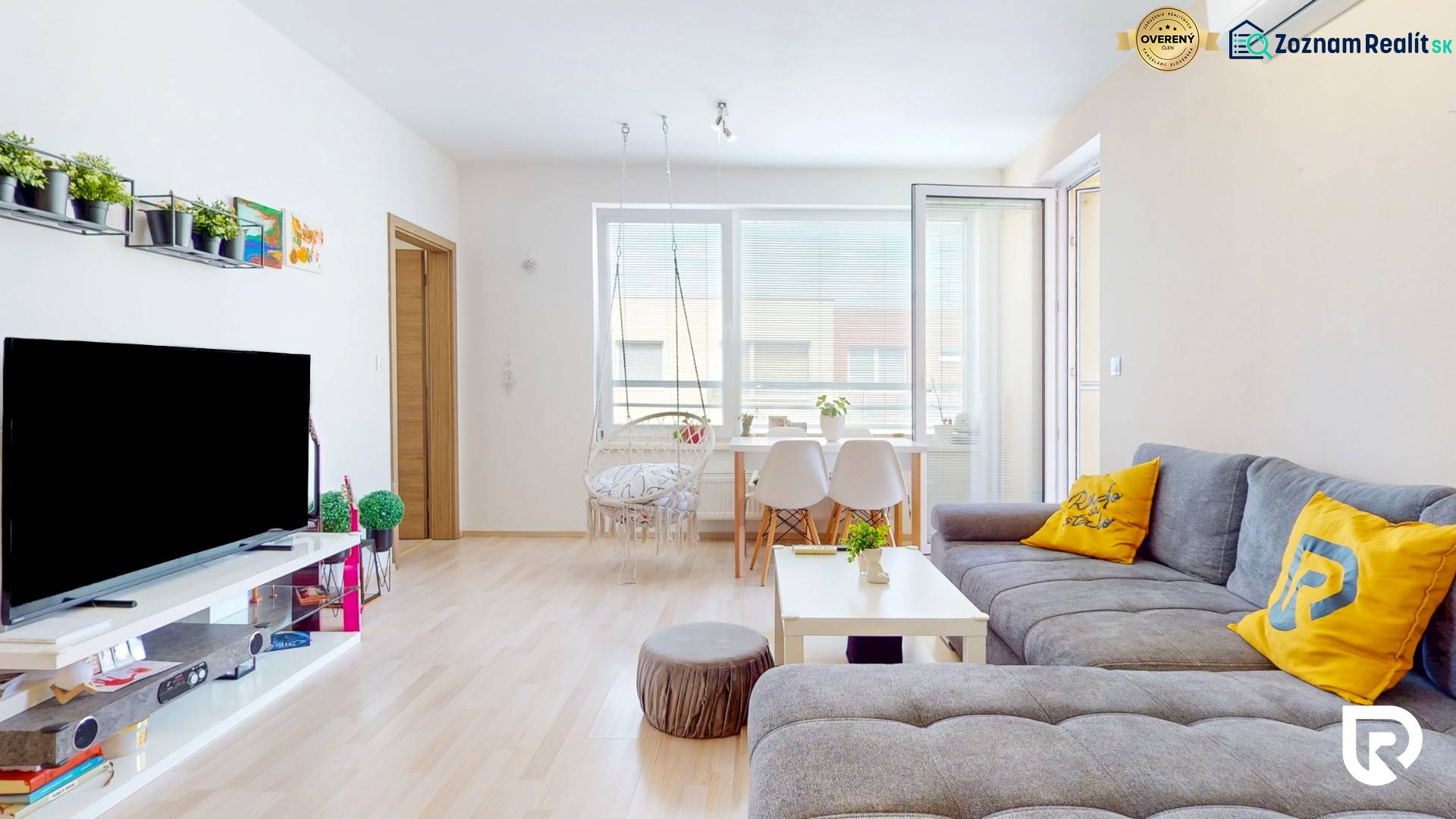 4i byt s terasou a parkovaním v tichej časti Rovinky | 89m2 - Svetlá obývacia izba v 4-izbovom byte s pohodlným gaučom a podlahou s dreveným dekorom.