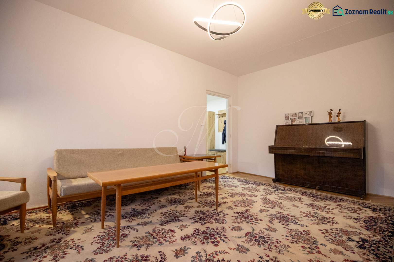 Slnečný 3-izbový byt, Kramáre - Obývačka v 3-izbovom byte s kobercovým dekorom a klavírom.