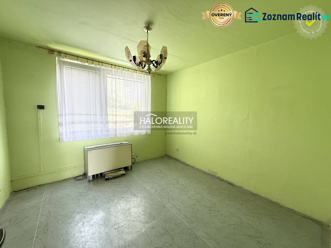 REZERVOVANÉ - Predaj, trojizbový byt Skačany + poliz... - Izba s lustrom, oknom a vykurovacím telesom v 3-izbovom byte.