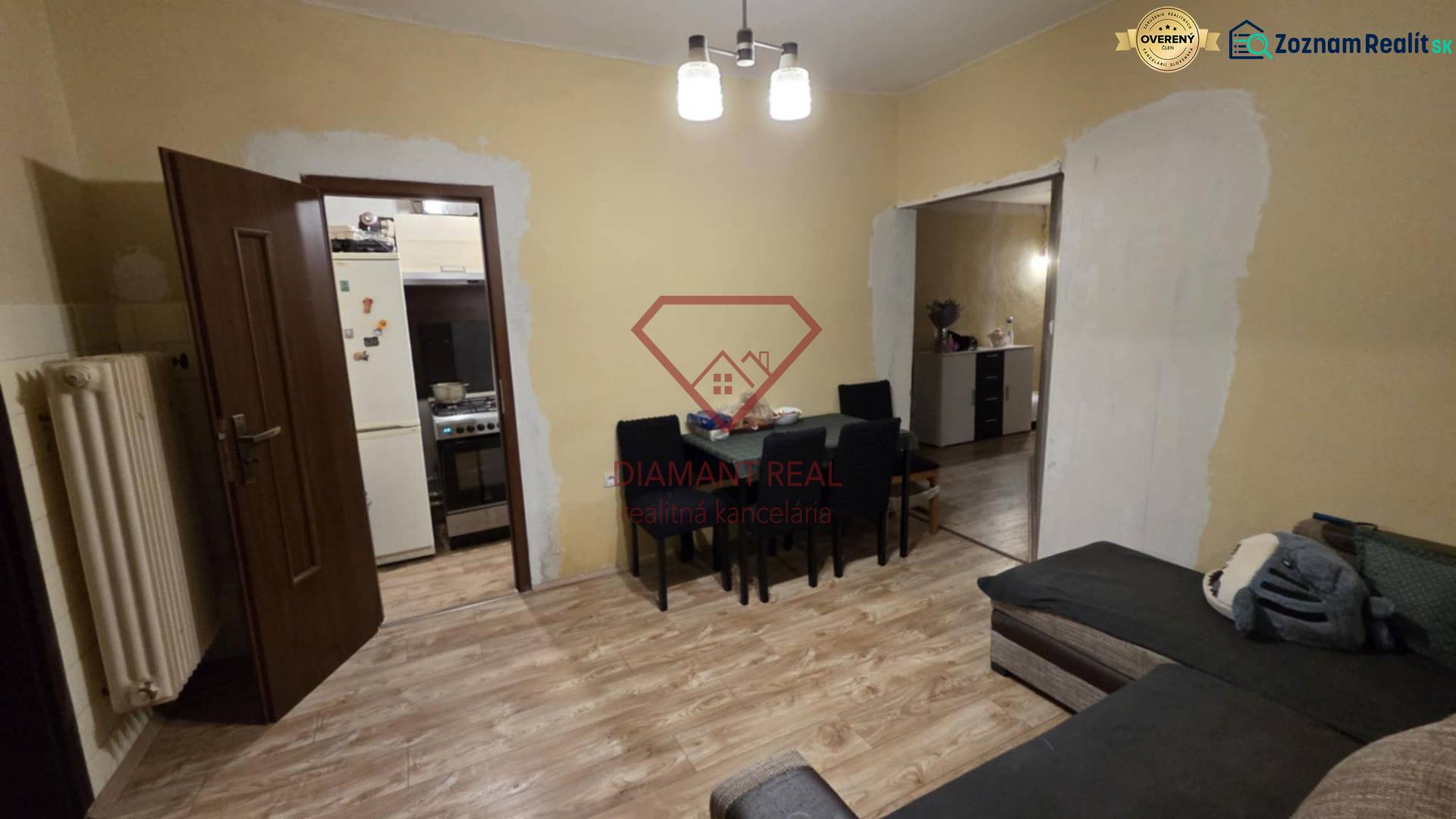 AKCIA - 2 Rodinné domy za cenu jedného obec Veľká Mača  - Obývacia izba v rodinnom dome s podlahou s dreveným dekorom, stolom a pohovkou.