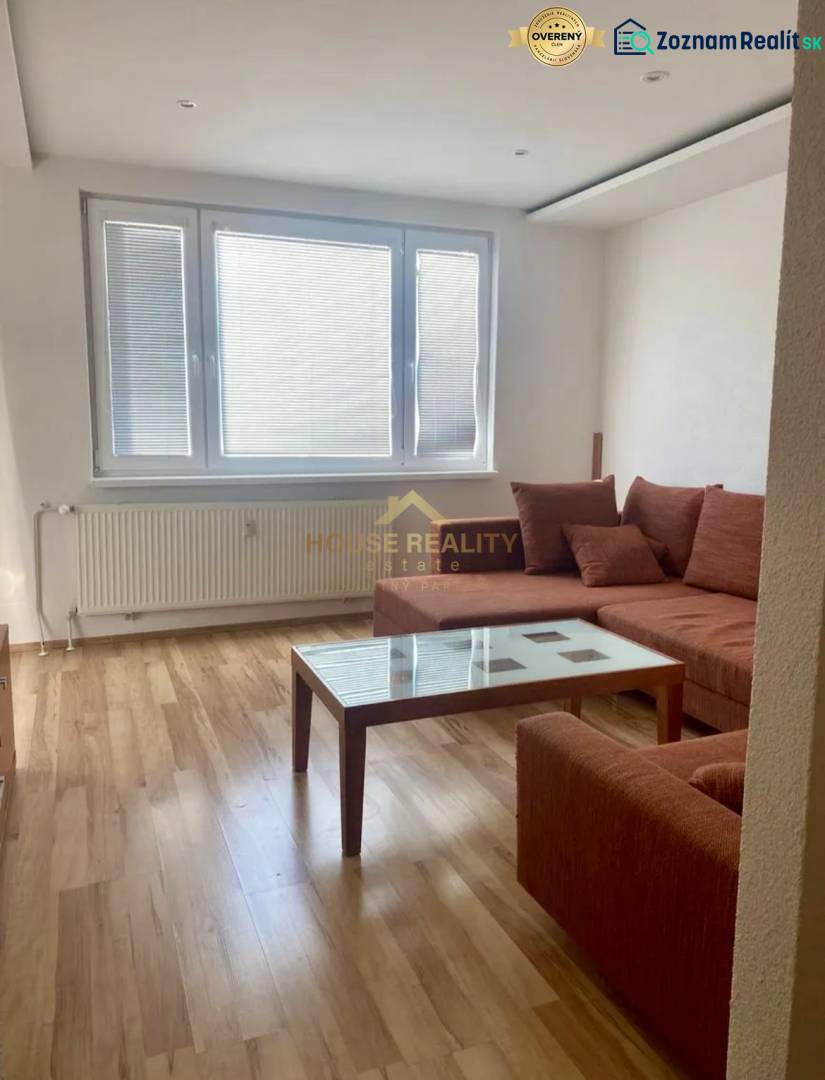 Pekný 3 izbový byt s lodžiou, ulica Nad Lúčkami, BA IV. Karlova Ves - Obývacia izba v 3-izbovom byte s podlahou s dreveným dekorom a pohovkou.