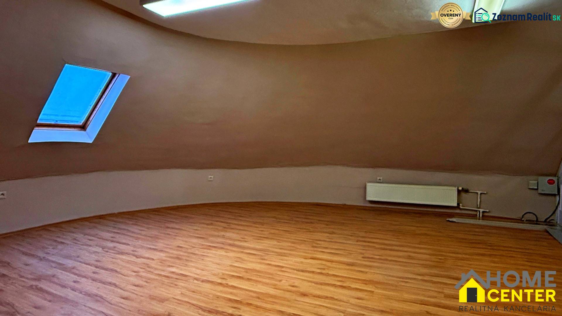 Na predaj unikátna dvojpodlažná budova na podnikanie aj bývanie - Podkrovná izba s oknom, radiátorom a podlahou s dreveným dekorom.