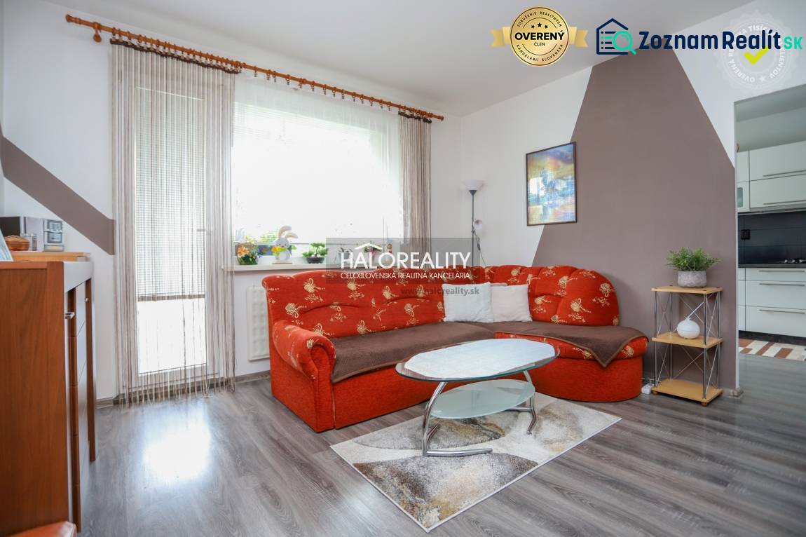 REZERVOVANÉ - Predaj, trojizbový byt Považská Bystri... - Obývacia izba v 3-izbovom byte s oranžovou sedačkou a podlahou s dreveným dekorom.