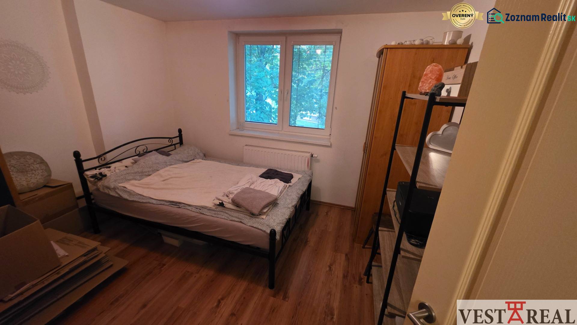 Na prenájom 3 izbový byt z balkónom a parkovacím miestom - Spálňa v 3-izbovom byte s kovovou posteľou a podlahou s dreveným dekorom.