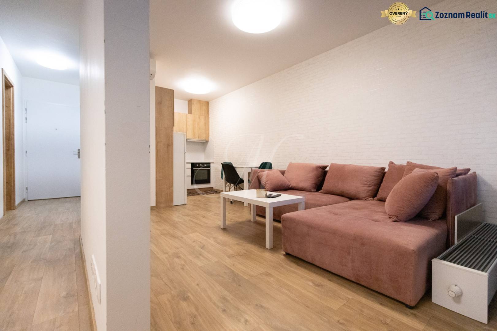 Zariadený 2i byt s lodžiou v rezidencii Pri Mýte - Obývacia izba v 2-izbovom byte s pohodlnou sedačkou a podlahou s dreveným dekorom.