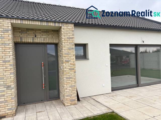Na predaj dizajnový 4-izbový rodinný dom v Tomášove - Rodinný dom na Fialkovej v Tomášove s tehlovým obkladom a priestrannými sklenenými dverami.
