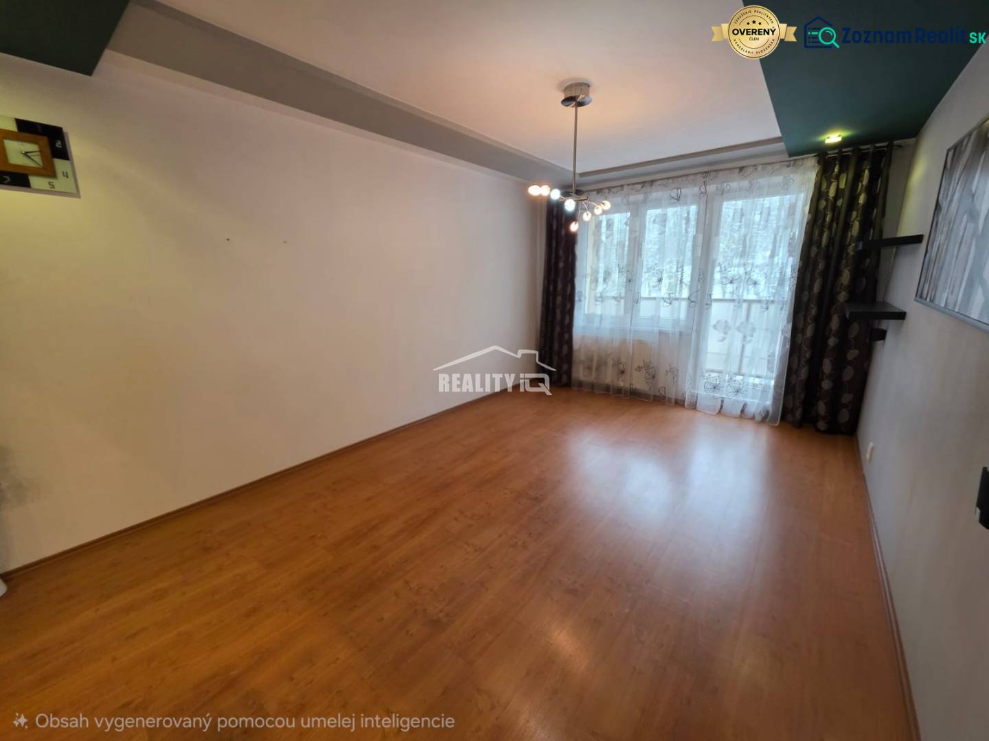 Na predaj priestranný 4-izbový byt 87 m2, Považská Bystrica - Obývačka 4-izbového bytu s podlahou s dreveným dekorom a veľkým oknom.