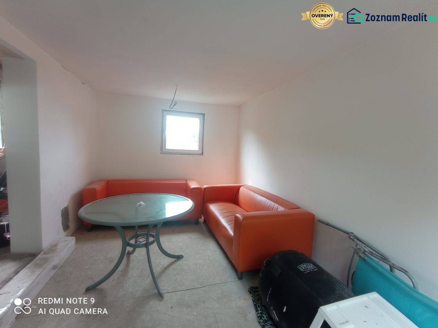 REZERVOVANÉ Chatka na krásnom mieste v kľudnom prostredí - Oranžové sedačky a okrúhly stôl dopĺňajú priestor v chate s bielymi stenami.